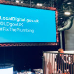 Local Digital twitter handle and #FixThePlumbing hashtag on projection screen